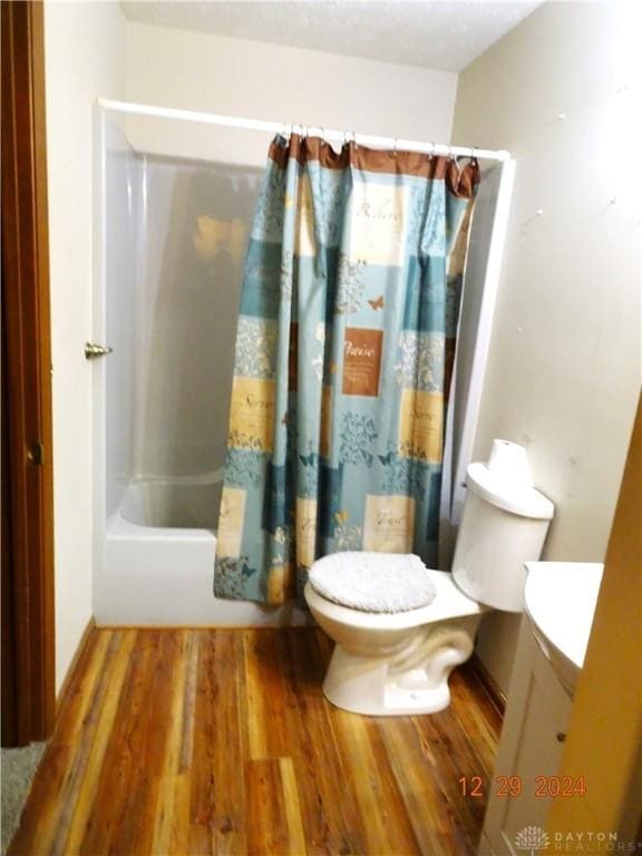 full bathroom with shower / tub combo, vanity, toilet, and wood-type flooring