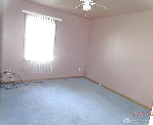 carpeted spare room with ceiling fan