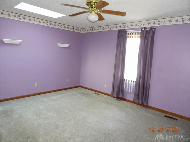 spare room with ceiling fan and light carpet