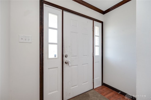 entrance foyer featuring ornamental molding, wood finished floors, and baseboards