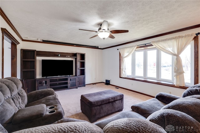 living area featuring baseboards, light colored carpet, ceiling fan, ornamental molding, and a textured ceiling