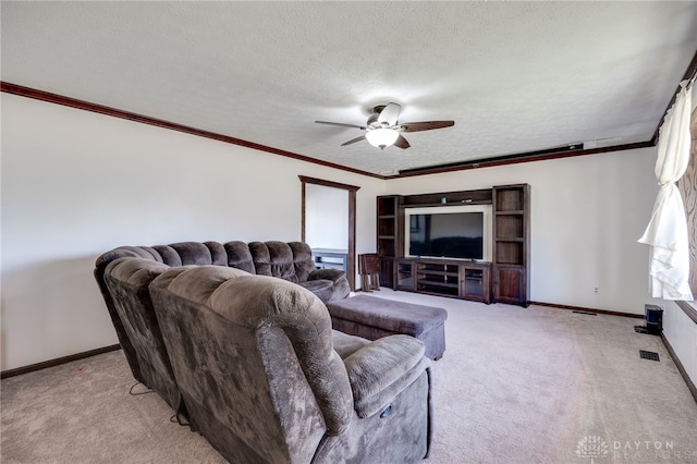 living area with a textured ceiling, light colored carpet, a ceiling fan, baseboards, and crown molding