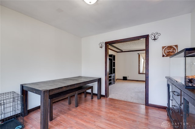 dining area featuring light wood-style floors and baseboards