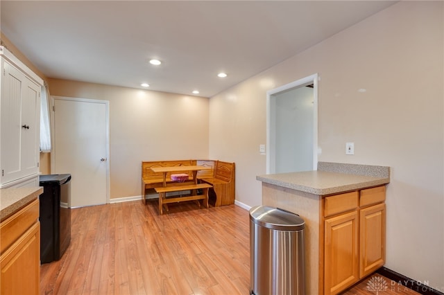 kitchen featuring light wood-type flooring, baseboards, light countertops, and recessed lighting