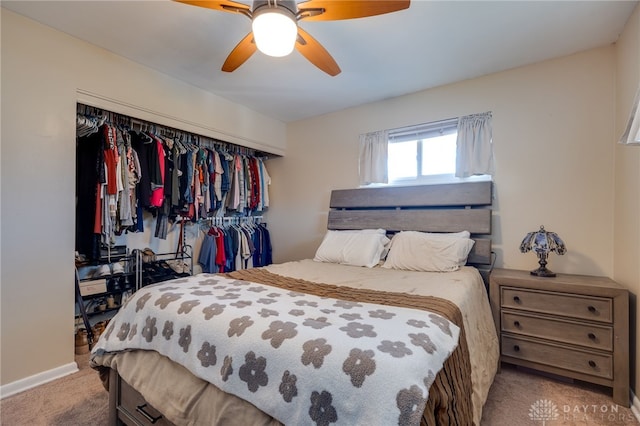 bedroom with a ceiling fan, a closet, and light carpet