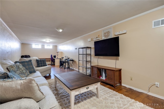 living room with baseboards, crown molding, visible vents, and wood finished floors