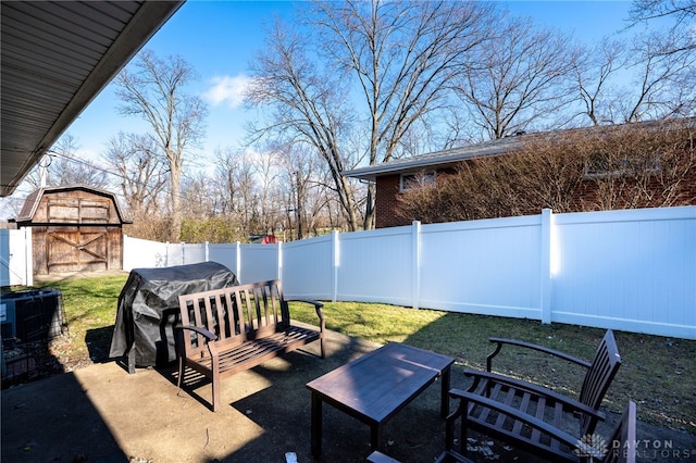 view of yard with an outbuilding, a fenced backyard, and a storage unit