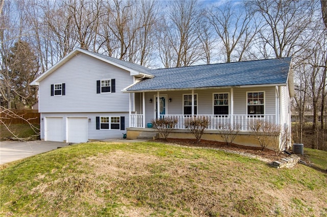 split level home with central AC unit, a garage, and a front lawn