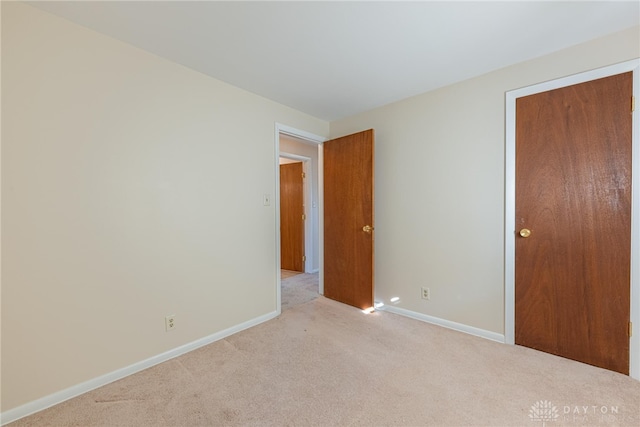 unfurnished bedroom featuring light carpet