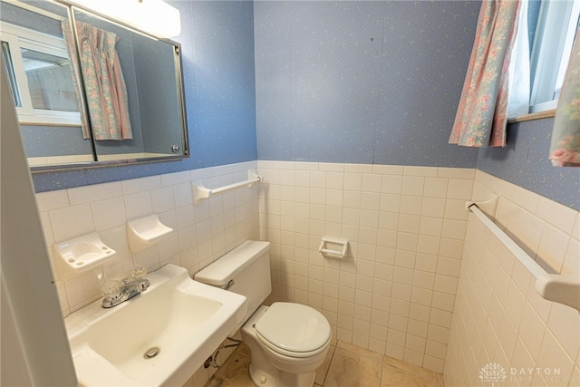 bathroom with tile walls, sink, tile patterned floors, and toilet