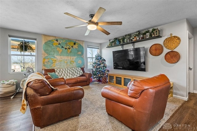 living room featuring ceiling fan, wood-type flooring, and a textured ceiling