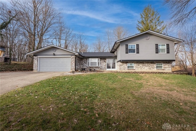 tri-level home featuring a garage and a front lawn