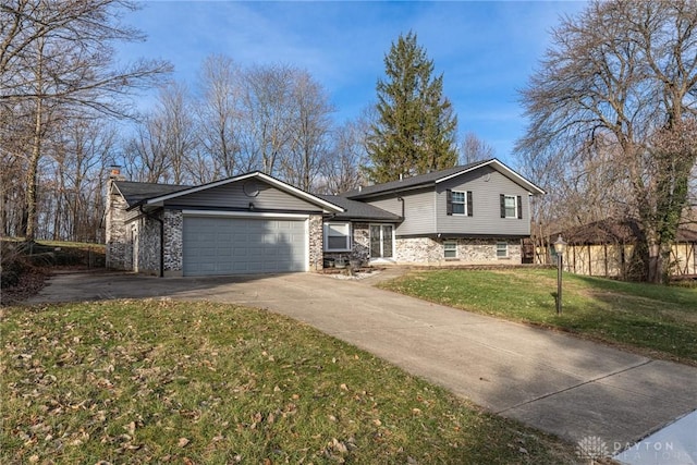 tri-level home featuring a garage and a front lawn