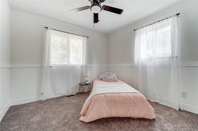 bedroom with multiple windows, ceiling fan, and carpet