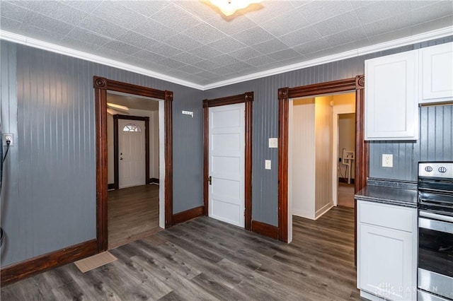 kitchen featuring dark hardwood / wood-style floors, stove, white cabinetry, and crown molding