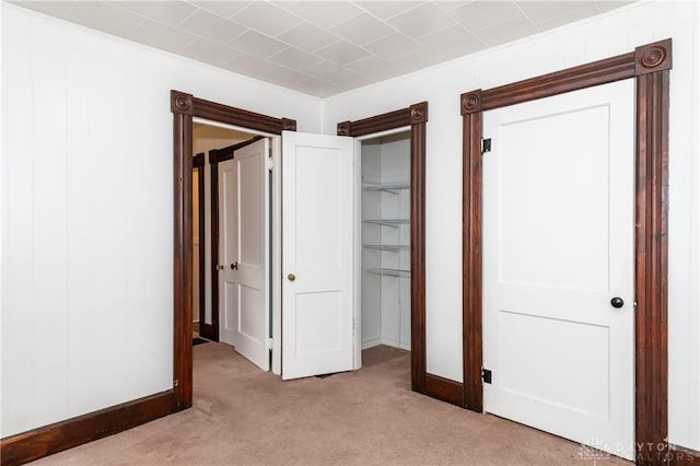 unfurnished bedroom with light carpet and a closet