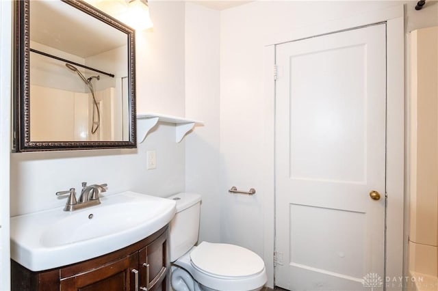 bathroom with walk in shower, vanity, and toilet