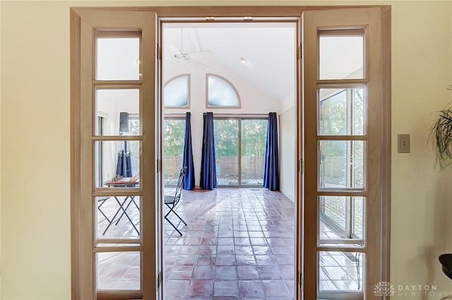 doorway featuring ceiling fan and vaulted ceiling