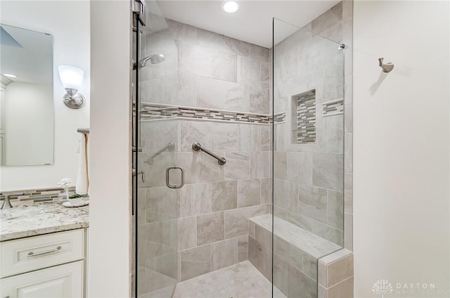 bathroom featuring vanity, an enclosed shower, and backsplash