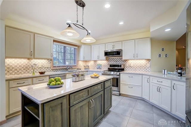 kitchen with a center island, white cabinets, hanging light fixtures, light stone counters, and stainless steel appliances