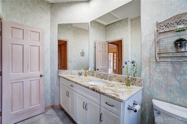 bathroom with toilet, vanity, and tile patterned floors