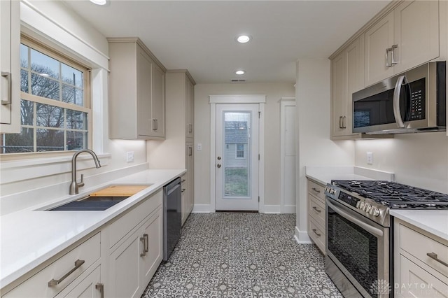 kitchen with gray cabinetry, a healthy amount of sunlight, sink, and stainless steel appliances