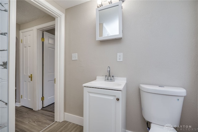 bathroom featuring hardwood / wood-style flooring, vanity, and toilet