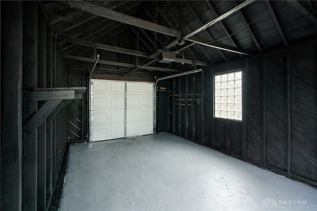 garage with a garage door opener and wooden walls