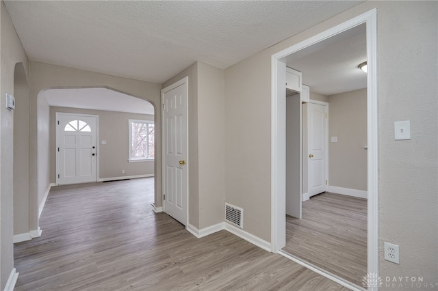 entrance foyer featuring a textured ceiling and light wood-type flooring