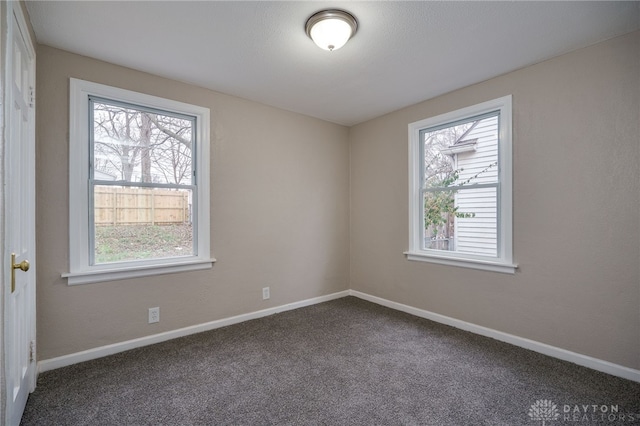 empty room with dark colored carpet