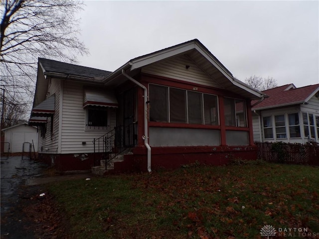 view of front of property featuring a front lawn and a sunroom