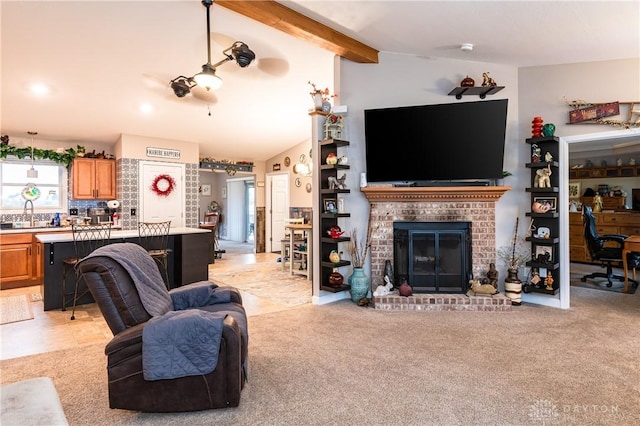 living room featuring lofted ceiling with beams, sink, light carpet, and a brick fireplace