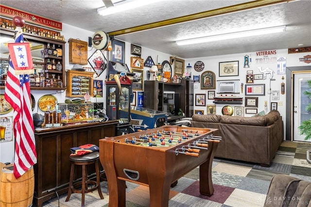 game room with bar area and a textured ceiling