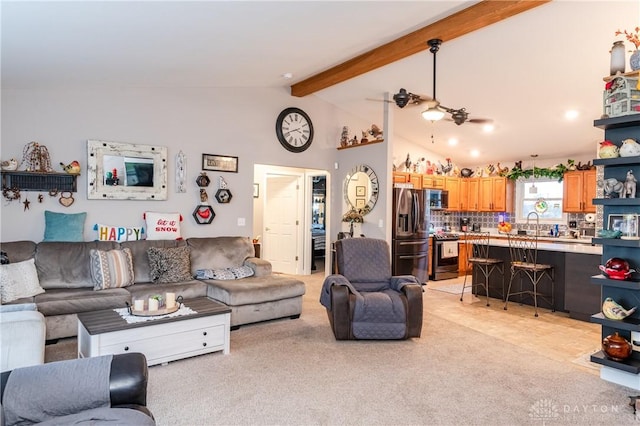 living room with light carpet, vaulted ceiling with beams, ceiling fan, and sink