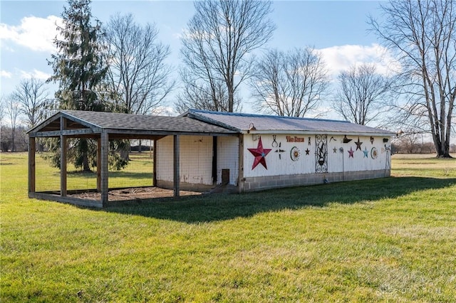 view of outdoor structure with a carport and a lawn