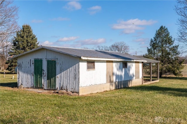 view of side of home with an outdoor structure and a yard