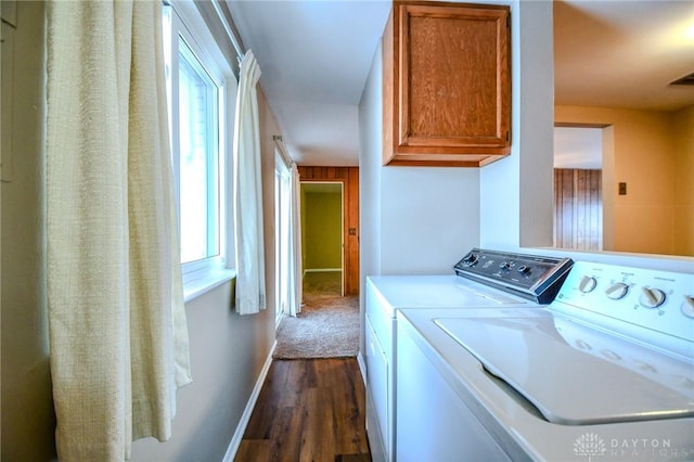 laundry room with washing machine and clothes dryer, dark hardwood / wood-style flooring, and cabinets