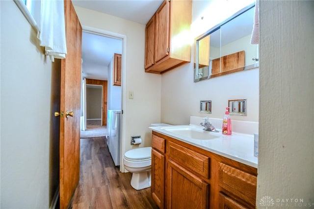 bathroom featuring toilet, vanity, and hardwood / wood-style flooring