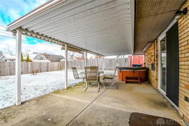 snow covered patio with a hot tub