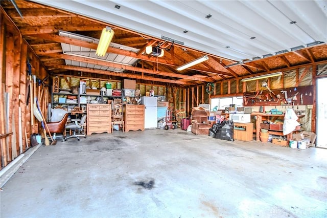 garage featuring white fridge and a garage door opener