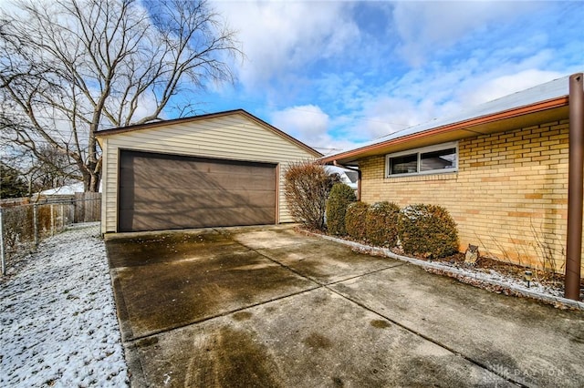 view of snow covered exterior featuring an outdoor structure and a garage