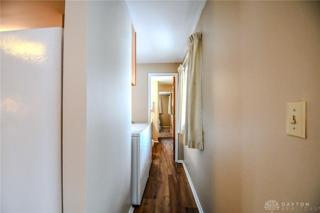 corridor with washer and clothes dryer and dark wood-type flooring