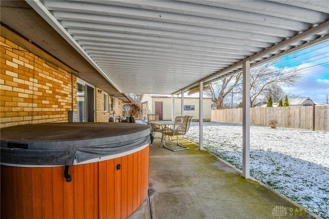 snow covered patio featuring a hot tub