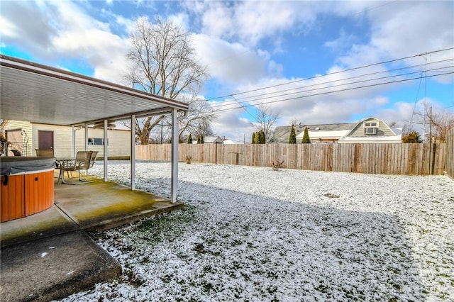 yard covered in snow featuring a patio area and a hot tub