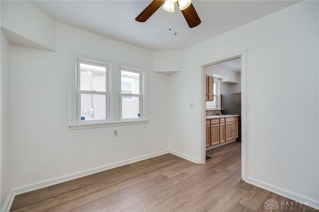 empty room featuring ceiling fan, light hardwood / wood-style flooring, and sink