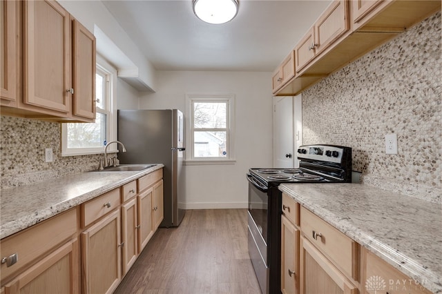 kitchen featuring sink, stainless steel appliances, light hardwood / wood-style flooring, backsplash, and light brown cabinetry