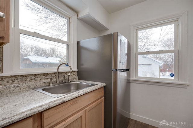 kitchen featuring stainless steel fridge, a healthy amount of sunlight, sink, and dark wood-type flooring