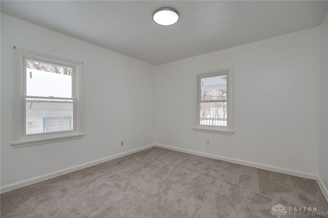 spare room featuring plenty of natural light and light colored carpet