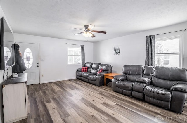 living room featuring hardwood / wood-style floors, a textured ceiling, plenty of natural light, and ceiling fan