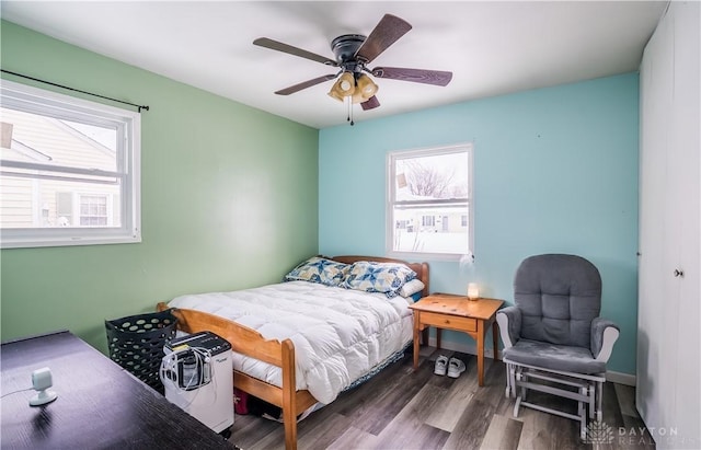 bedroom with dark hardwood / wood-style floors and ceiling fan